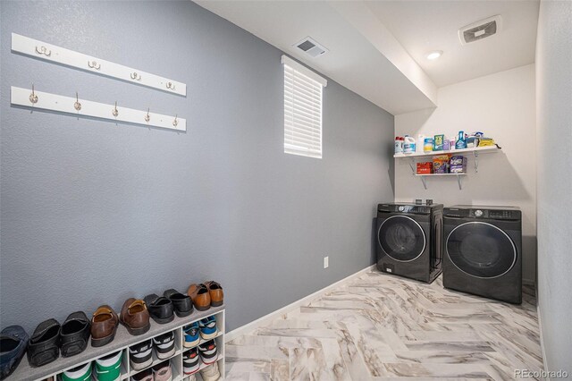 clothes washing area with washer and clothes dryer, laundry area, baseboards, and visible vents