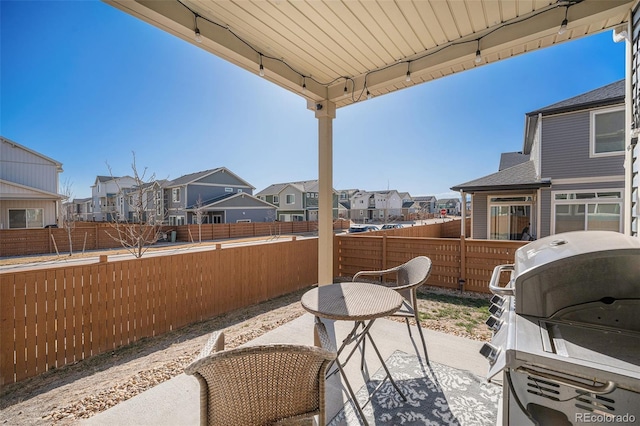 view of patio / terrace with grilling area, a residential view, and a fenced backyard