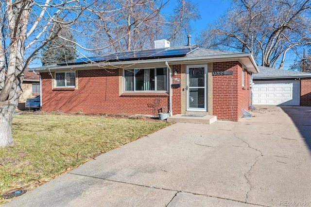 view of front facade featuring solar panels, a garage, and a front lawn