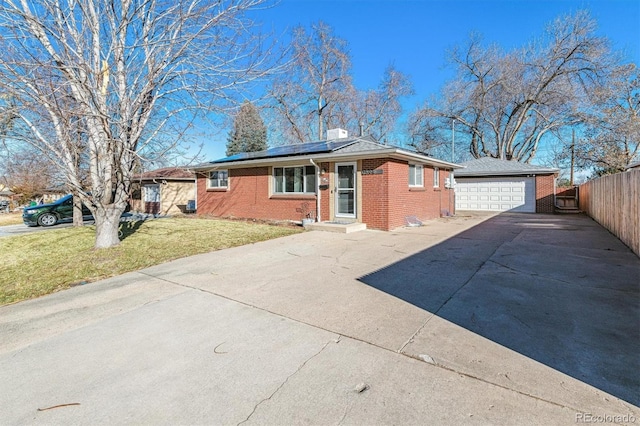 single story home featuring solar panels, a garage, and a front lawn