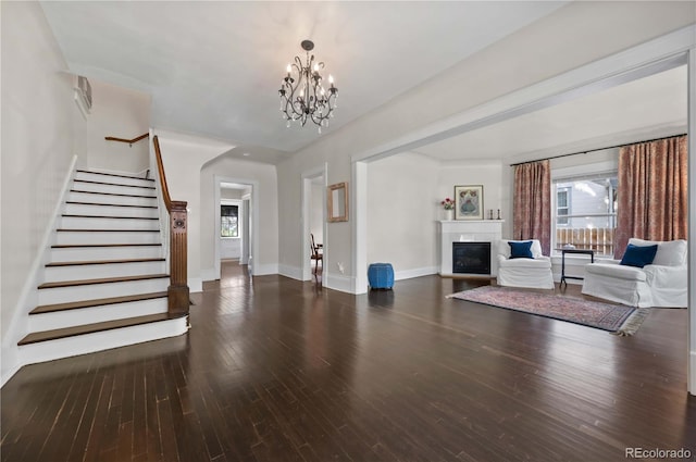 1024 Greenwood Ave, Canon City, CO 81212 - unfurnished living room with stairs, a chandelier, a glass covered fireplace, and wood finished floors
