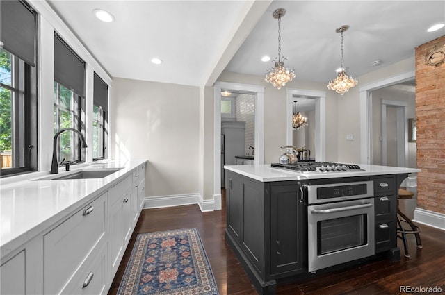1024 Greenwood Ave, Canon City, CO 81212 - kitchen with appliances with stainless steel finishes, a chandelier, dark cabinets, light countertops, and white cabinets