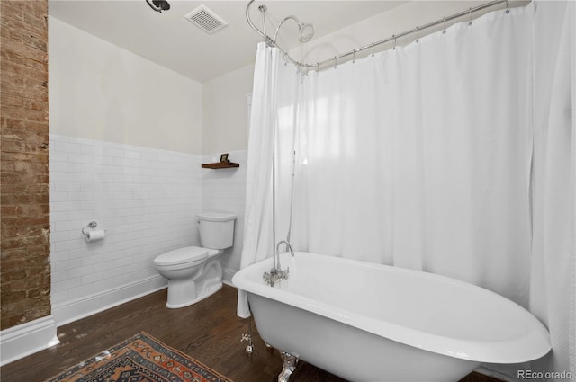 1024 Greenwood Ave, Canon City, CO 81212 - full bath with wood finished floors, a soaking tub, a wainscoted wall, and tile walls