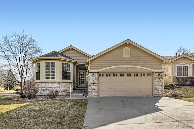 ranch-style house featuring stone siding, an attached garage, and concrete driveway