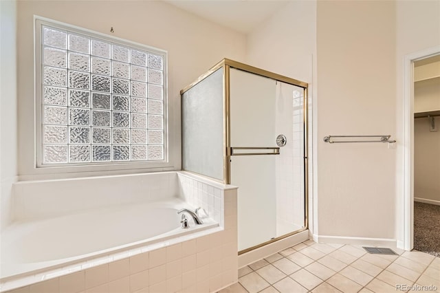 full bath featuring visible vents, tile patterned flooring, a shower stall, a walk in closet, and a garden tub