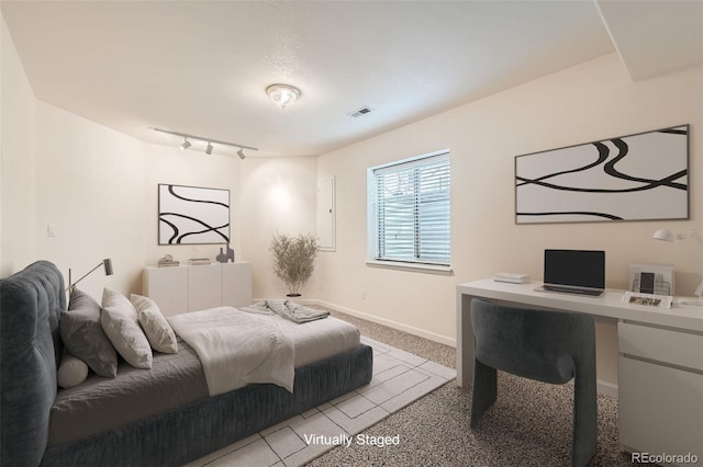 bedroom with track lighting, baseboards, visible vents, and light carpet