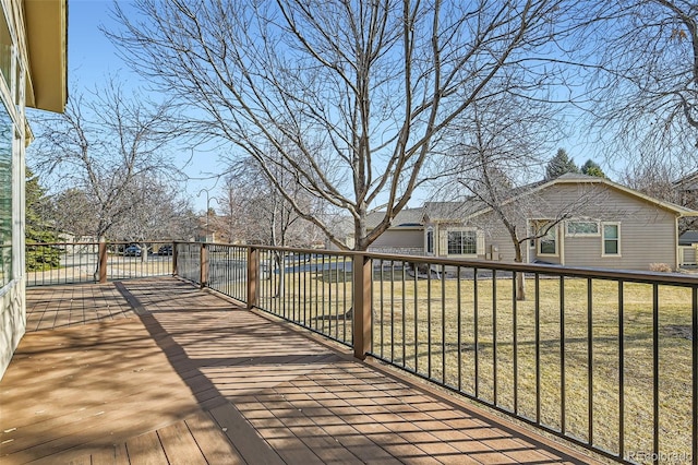 wooden terrace featuring a lawn