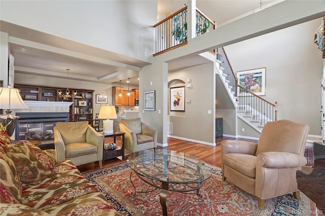 4545 S Monaco St Unit 114, Denver, CO 80237 - living area with a tiled fireplace, wood finished floors, stairs, and a chandelier