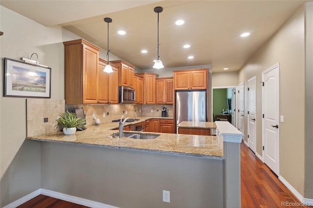 4545 S Monaco St Unit 114, Denver, CO 80237 - kitchen with appliances with stainless steel finishes, dark wood-style floors, decorative backsplash, a peninsula, and light stone countertops