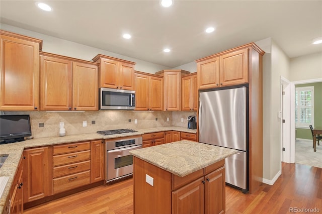 4545 S Monaco St Unit 114, Denver, CO 80237 - kitchen featuring stainless steel appliances, light wood-type flooring, light stone countertops, tasteful backsplash, and recessed lighting