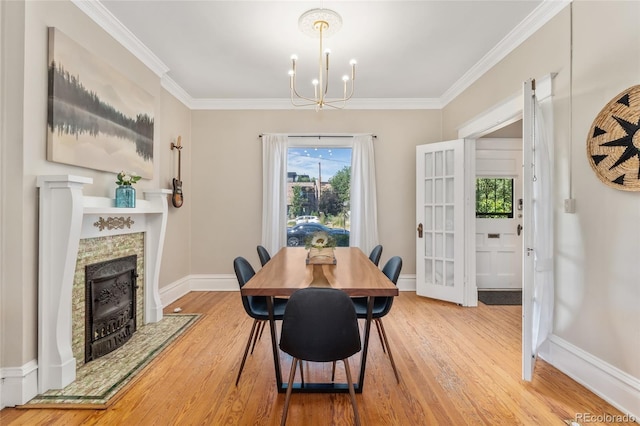 222 S Logan St, Denver, CO 80209 - dining space with wood finished floors, a chandelier, a tile fireplace, and crown molding