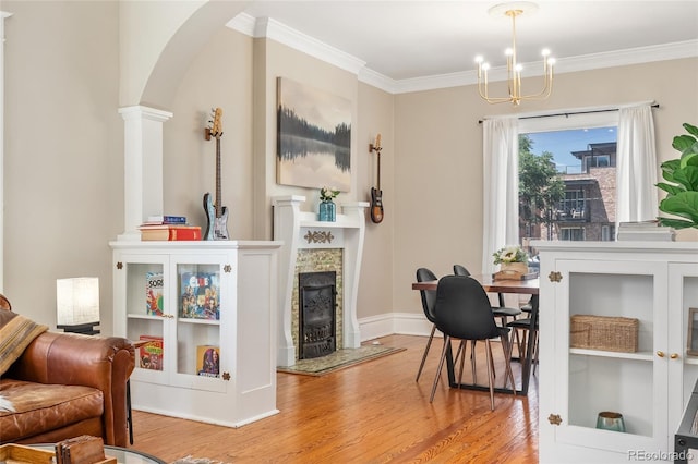 222 S Logan St, Denver, CO 80209 - living area featuring arched walkways, wood finished floors, a tiled fireplace, ornamental molding, and a chandelier