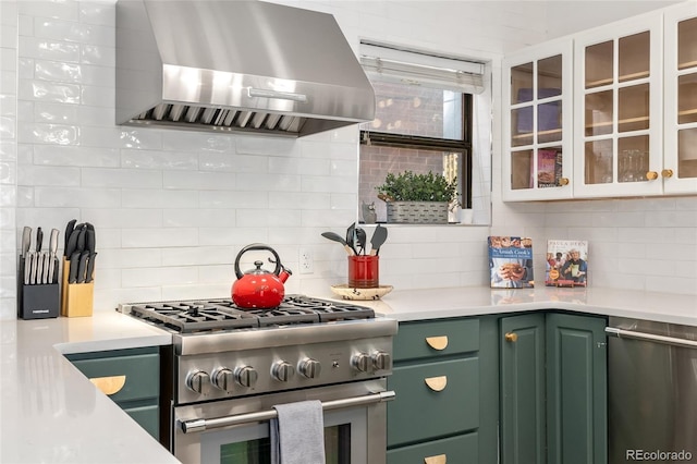 222 S Logan St, Denver, CO 80209 - kitchen featuring ventilation hood, green cabinets, appliances with stainless steel finishes, decorative backsplash, and light countertops