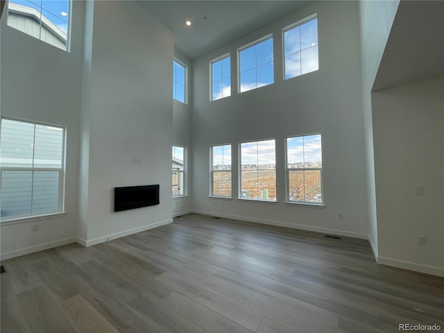 unfurnished living room with recessed lighting, baseboards, wood finished floors, and a fireplace