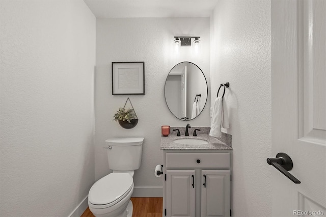 5554 S Ward Way, Littleton, CO 80127 - half bathroom with wood finished floors, vanity, toilet, and baseboards