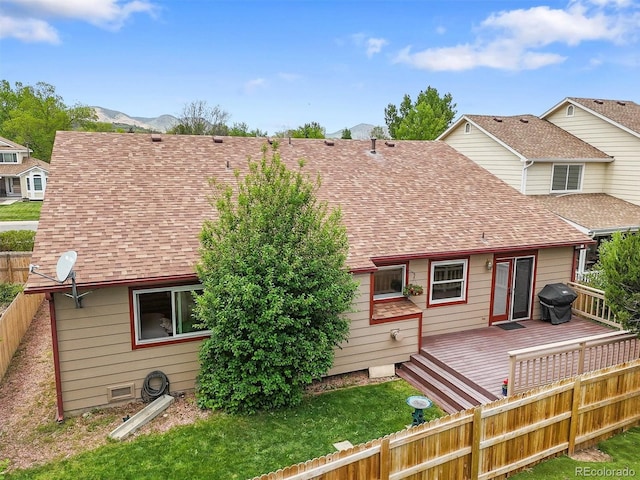 5554 S Ward Way, Littleton, CO 80127 - back of house with a fenced backyard, a deck with mountain view, and a shingled roof