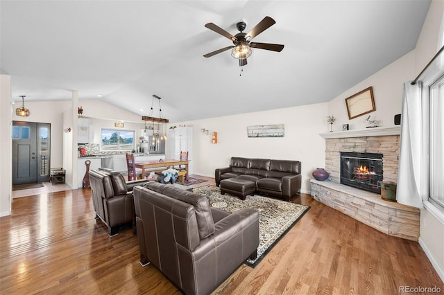 living room with ceiling fan, baseboards, lofted ceiling, a fireplace, and wood finished floors