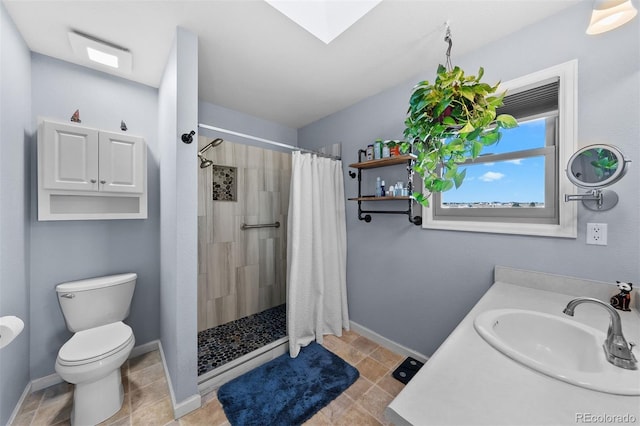 bathroom with a skylight, toilet, baseboards, and a tile shower