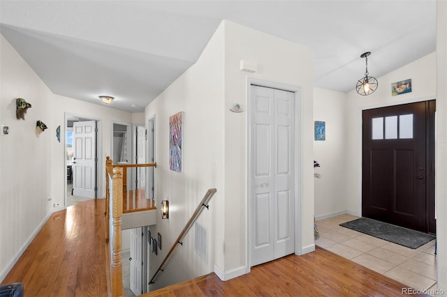 entrance foyer with vaulted ceiling, wood finished floors, and baseboards