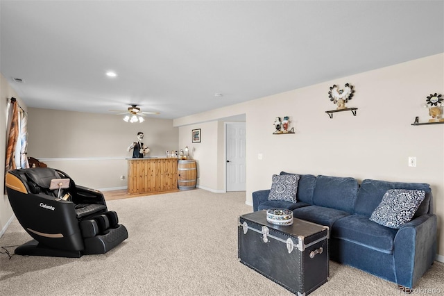 living area featuring baseboards, light carpet, visible vents, and a ceiling fan