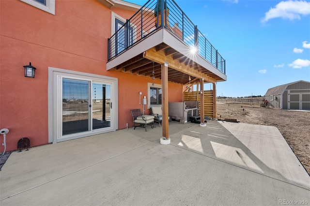 view of patio / terrace featuring a storage unit and an outbuilding