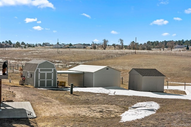 view of yard with a rural view, a storage shed, and an outbuilding