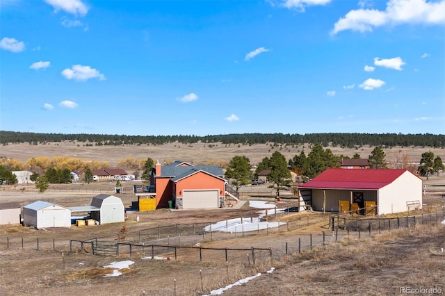 view of yard featuring an outbuilding, a rural view, and a detached garage