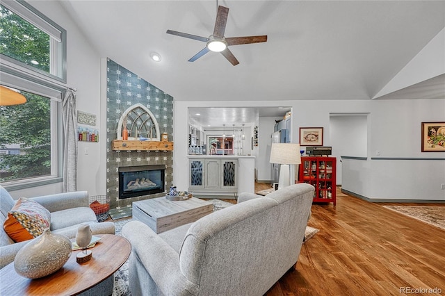 11820 W 66th Pl Unit C, Arvada, CO 80004 - living area featuring high vaulted ceiling, a tiled fireplace, a ceiling fan, plenty of natural light, and wood finished floors