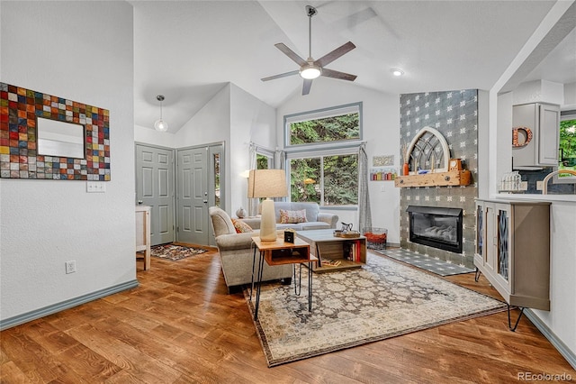 11820 W 66th Pl Unit C, Arvada, CO 80004 - living area featuring ceiling fan, a tile fireplace, healthy amount of natural light, wood finished floors, and high vaulted ceiling