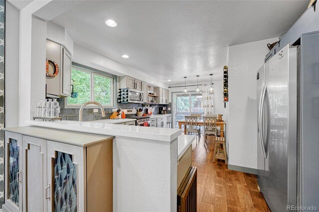 11820 W 66th Pl Unit C, Arvada, CO 80004 - kitchen with stainless steel appliances, light countertops, tasteful backsplash, plenty of natural light, and recessed lighting