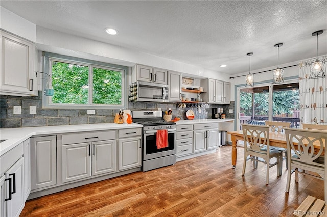 11820 W 66th Pl Unit C, Arvada, CO 80004 - kitchen featuring appliances with stainless steel finishes, plenty of natural light, decorative backsplash, a textured ceiling, and light countertops