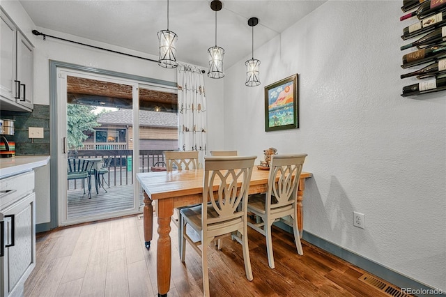 11820 W 66th Pl Unit C, Arvada, CO 80004 - dining room featuring light wood-style floors, a textured wall, and baseboards