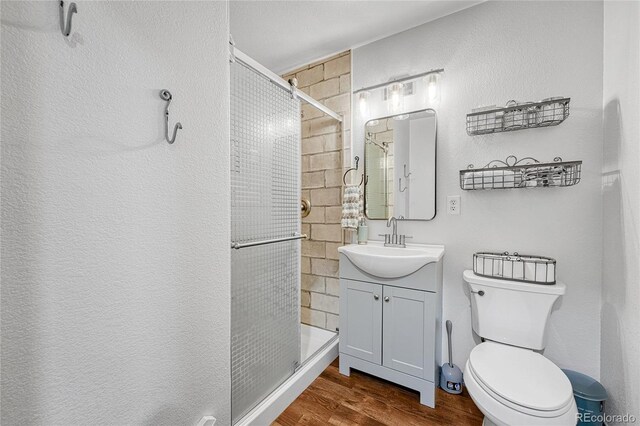 11820 W 66th Pl Unit C, Arvada, CO 80004 - full bathroom featuring wood finished floors, vanity, a shower stall, and toilet