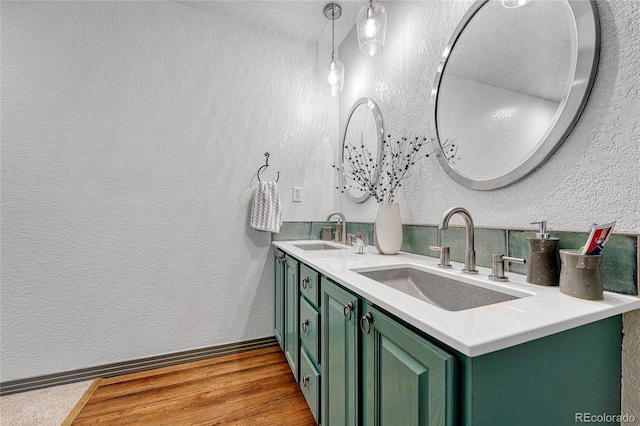 11820 W 66th Pl Unit C, Arvada, CO 80004 - bathroom featuring double vanity, a textured wall, wood finished floors, and baseboards