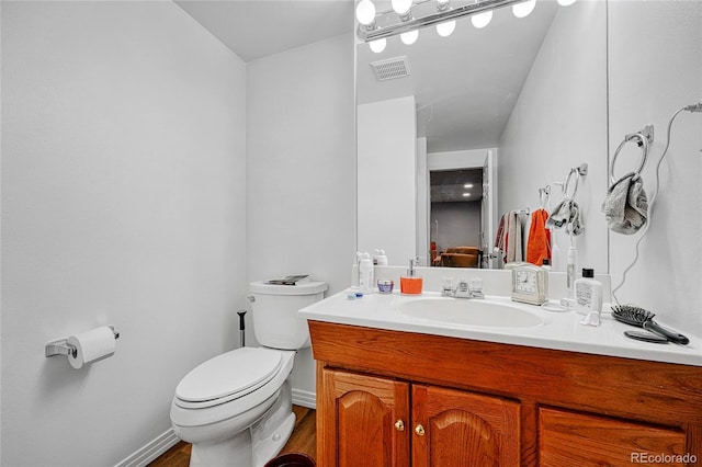 11820 W 66th Pl Unit C, Arvada, CO 80004 - bathroom featuring toilet, vanity, wood finished floors, and baseboards