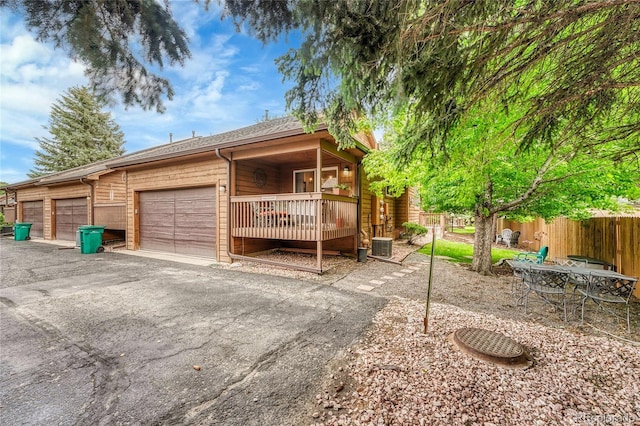 11820 W 66th Pl Unit C, Arvada, CO 80004 - view of side of property featuring asphalt driveway, a garage, and central AC