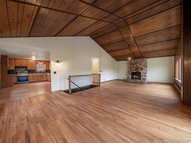 unfurnished living room with a fireplace, high vaulted ceiling, wooden ceiling, and light wood-type flooring