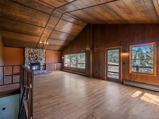 unfurnished living room featuring a wealth of natural light, light hardwood / wood-style floors, baseboard heating, and wood ceiling