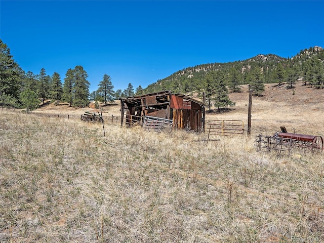 view of yard with a mountain view, a rural view, and an outdoor structure