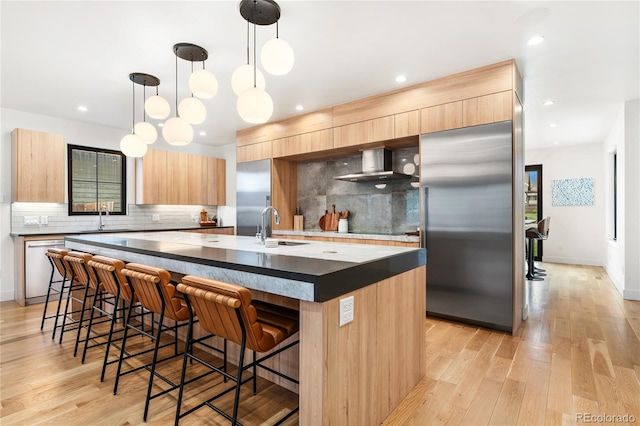 1675 S Steele St, Denver, CO 80210 - kitchen with stainless steel fridge, wall chimney range hood, modern cabinets, light brown cabinets, and recessed lighting