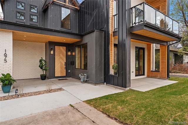 1675 S Steele St, Denver, CO 80210 - property entrance featuring a balcony, brick siding, a patio, and a yard