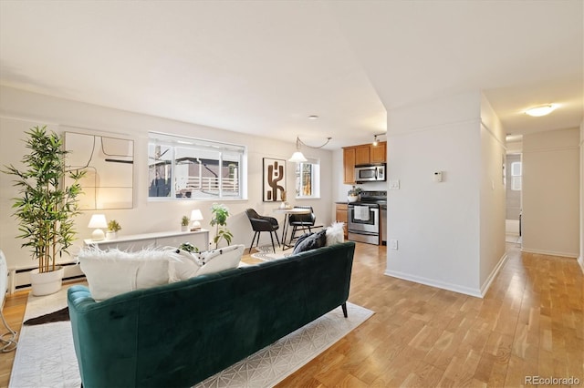 living area featuring light wood-style floors, baseboards, and baseboard heating