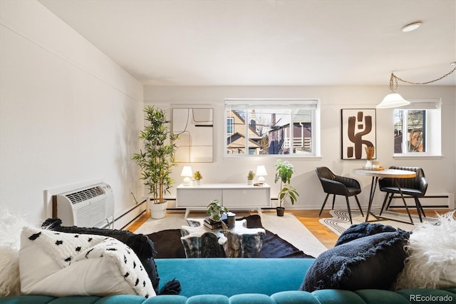 living room featuring light hardwood / wood-style floors, a baseboard heating unit, a healthy amount of sunlight, and a wall mounted AC