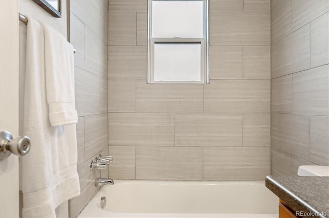 bathroom featuring tiled shower / bath and vanity