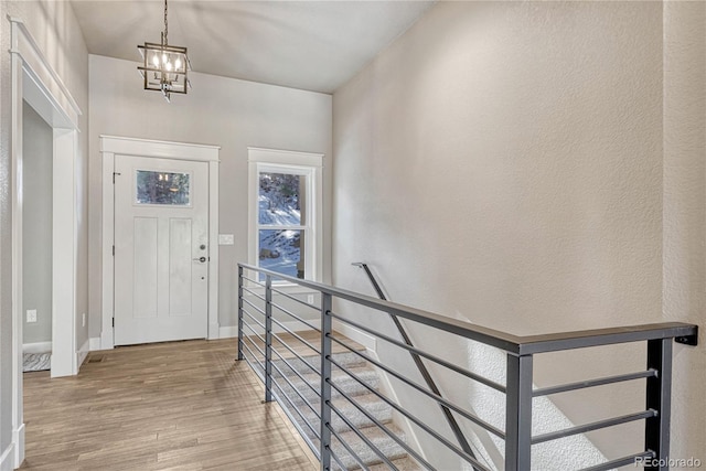 foyer with wood-type flooring and a chandelier