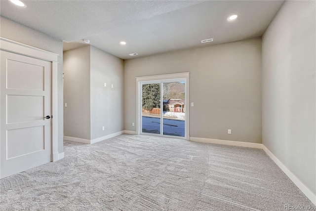 carpeted spare room featuring a textured ceiling