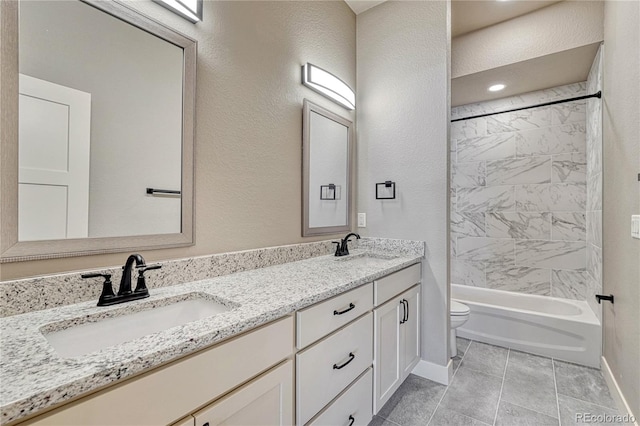 full bathroom featuring tiled shower / bath, vanity, and toilet