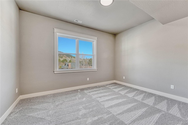 unfurnished room featuring a textured ceiling and carpet