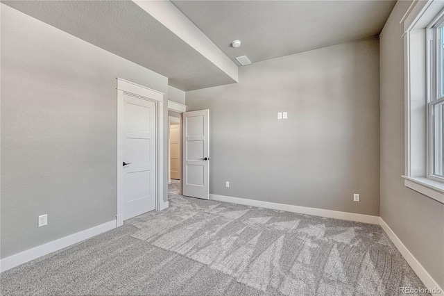 unfurnished room featuring light carpet