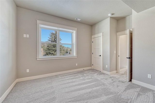 interior space featuring light carpet and a textured ceiling